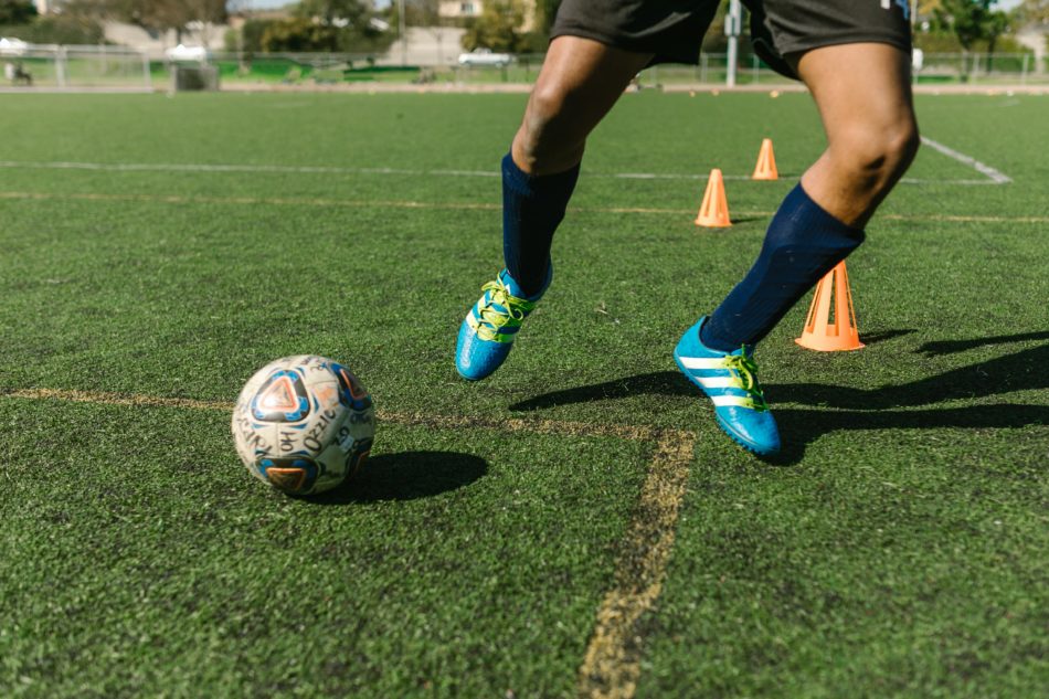 futbolista kājas un futbola bumba