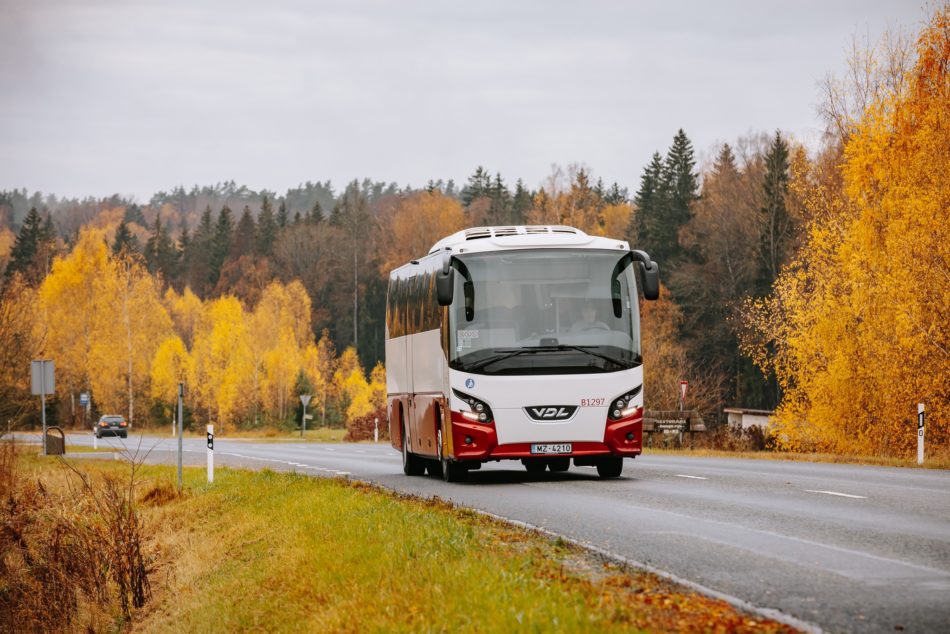 autobuss uz ceļa, fonā rudenīgi koki