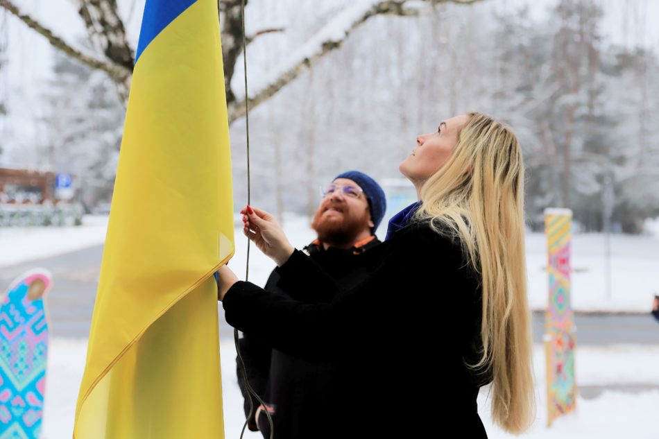 Domes priekšsēdētāja Karīna miķelsone un mācītājs Aigars Vančenko paceļ Ukrainas karogu